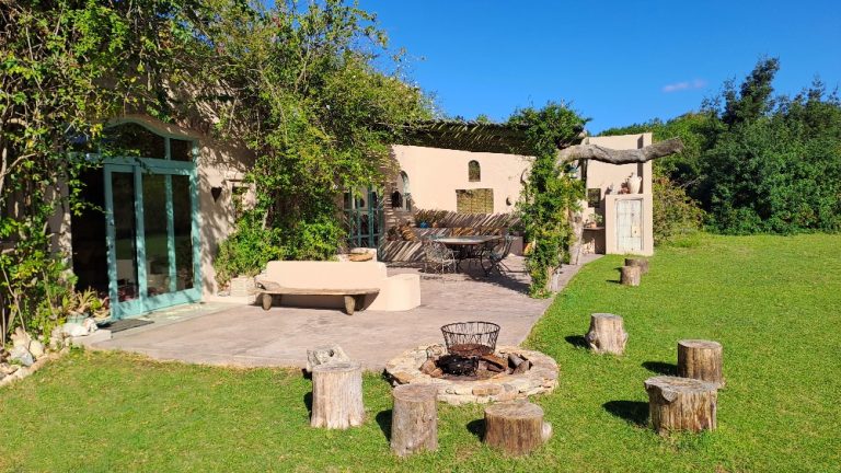 Akasha Mountain Retreat tranquil outdoor garden and patio area with rustic firepit seating, lush greenery, and peaceful countryside retreat living.