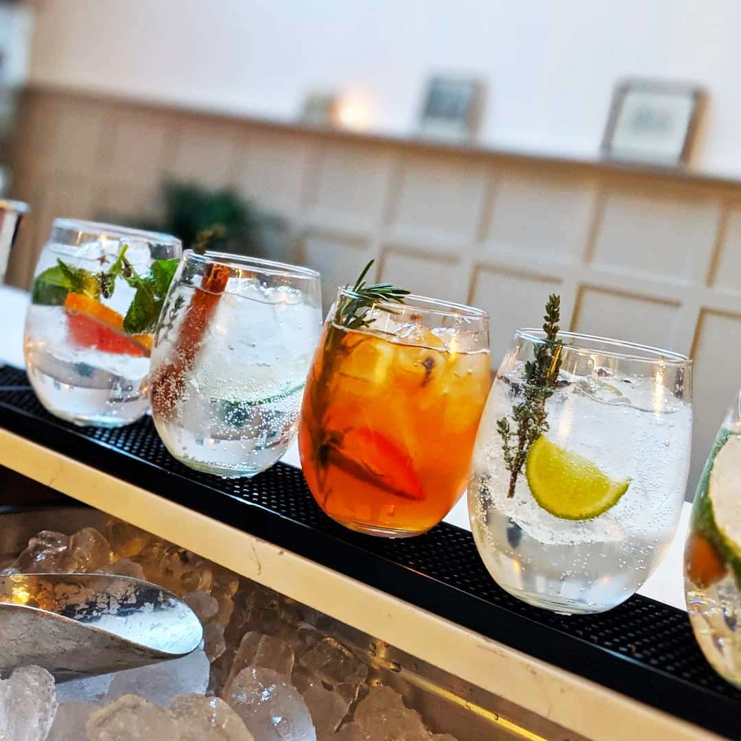 Colorful cocktails on a rooftop terrace with a scenic view of Cape Town and Table Mountain at sunset.