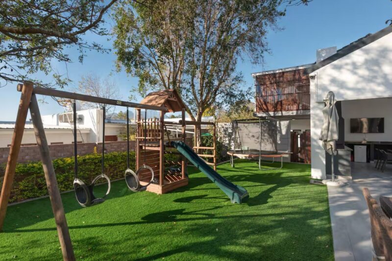 Paradyskloof Family Retreat expansive garden with jungle gym and outdoor entertainment area
