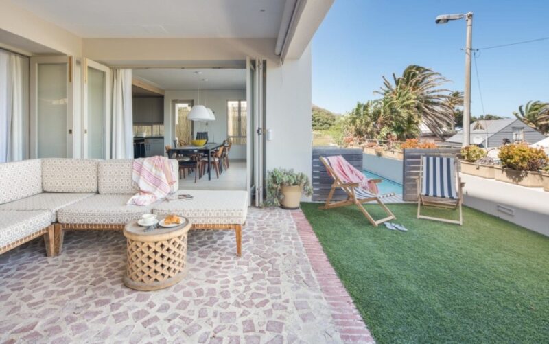 Villa 52 Victoria – Spacious outdoor patio with comfortable lounge seating, opening seamlessly from the elegant living area and offering the perfect setting for relaxed afternoons in the fresh coastal air.