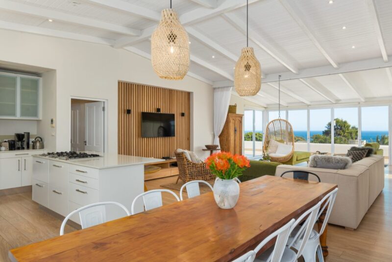 Open-plan kitchen, dining, and lounge area with ocean views, vaulted ceilings, and seamless indoor-outdoor living.