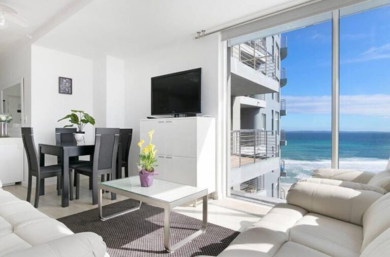 Contemporary lounge and dining area with floor-to-ceiling ocean views at Horizon Bay 1106