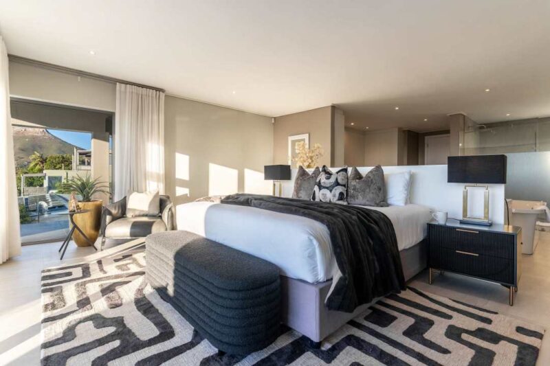 Ottawa Grand luxurious master suite featuring elegant contemporary design, private balcony access, abundant natural light, and breathtaking mountain views in the heart of Camps Bay.