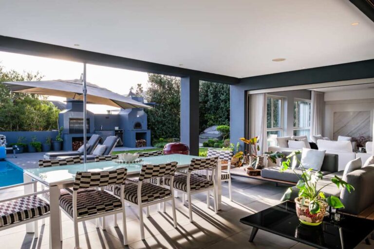 Stylish covered patio with poolside dining and relaxed lounge at Azzura