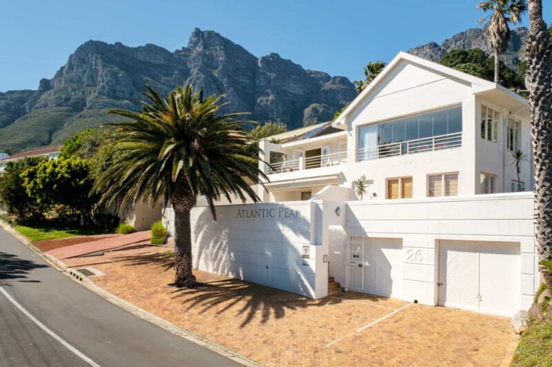 Elegant villa exterior with mountain backdrop and palm-lined entrance at Atlantic Tide