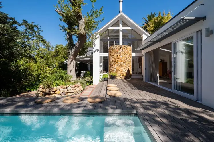 Upper Paradise private pool deck surrounded by lush gardens and towering trees, creating a peaceful indoor–outdoor retreat in the heart of leafy Newlands.