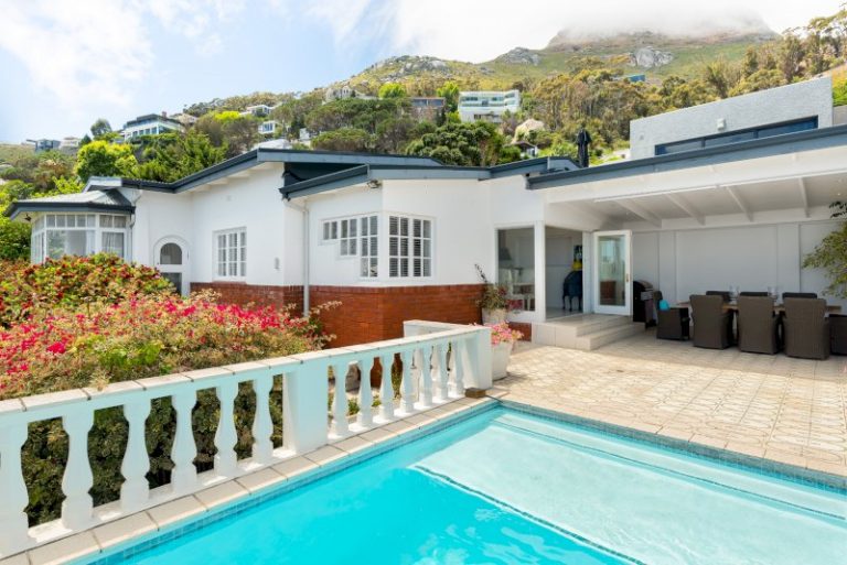 Luxury Clifton Villa private infinity-edge pool terrace with outdoor dining area and dramatic mountain backdrop above Clifton’s coastline.