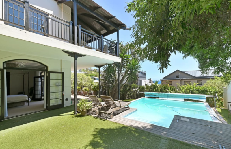 Bali House Llandudno – Private swimming pool and sun deck surrounded by lush tropical gardens, creating a tranquil oasis just moments from the beach.
