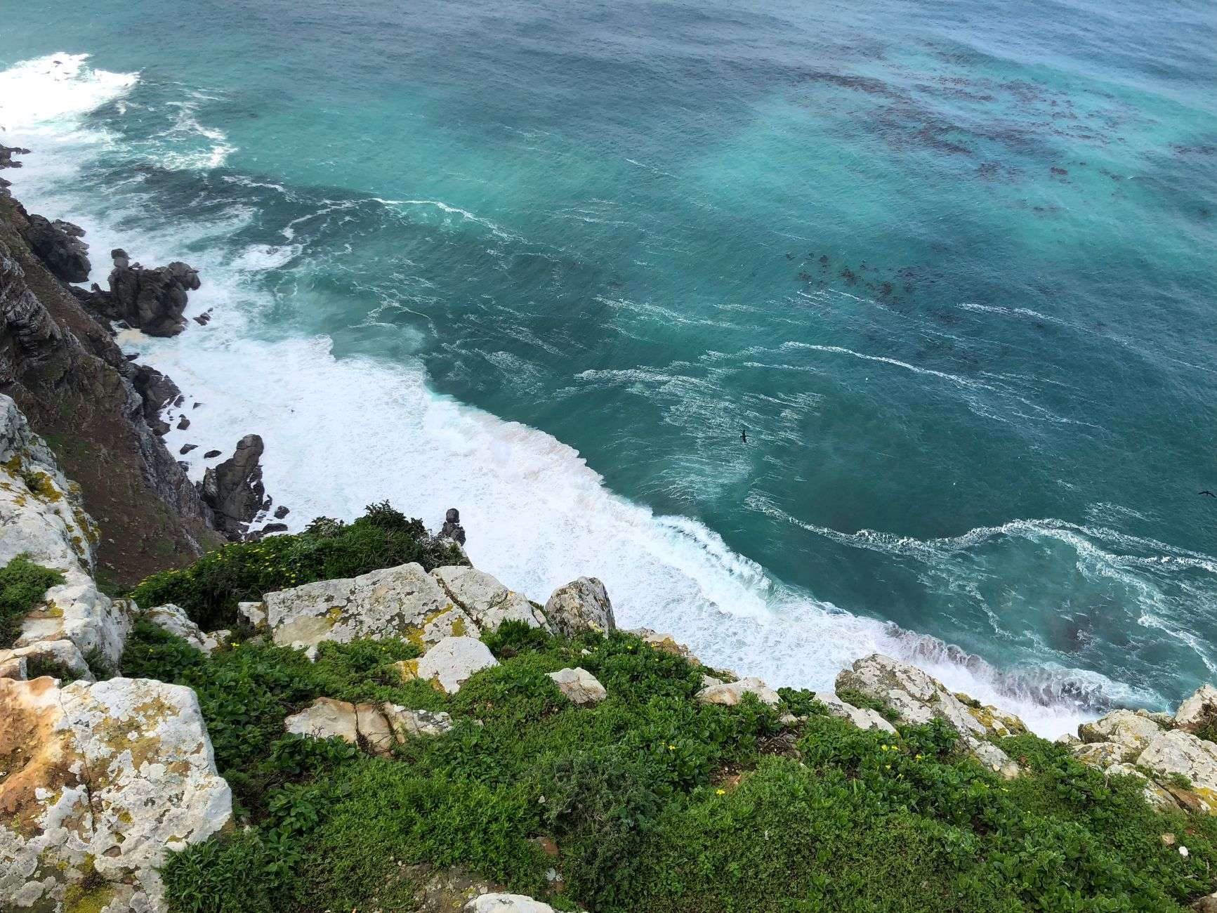 Aerial view of Cape Town’s coastline with turquoise sea and rocky cliffs, suited to a secluded Atlantic Seaboard cove.