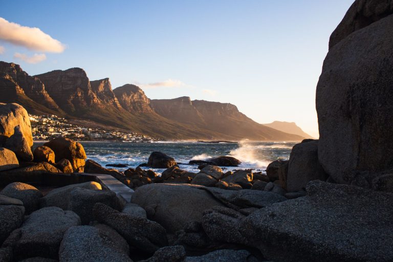 Camps Bay beach at sunset with the Twelve Apostles and Atlantic coastline in frame.