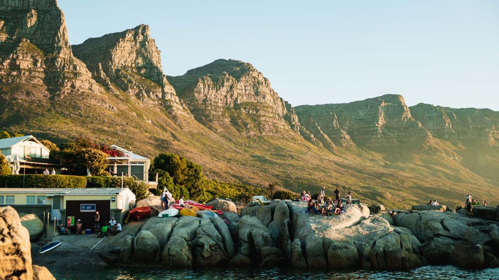 Cape Town’s Camps Bay coastline with mountain backdrop and bright waterfront light.