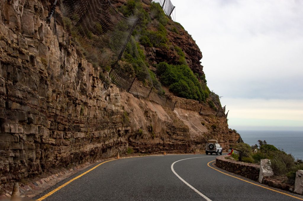 Car travelling along Chapman’s Peak Drive beside the ocean