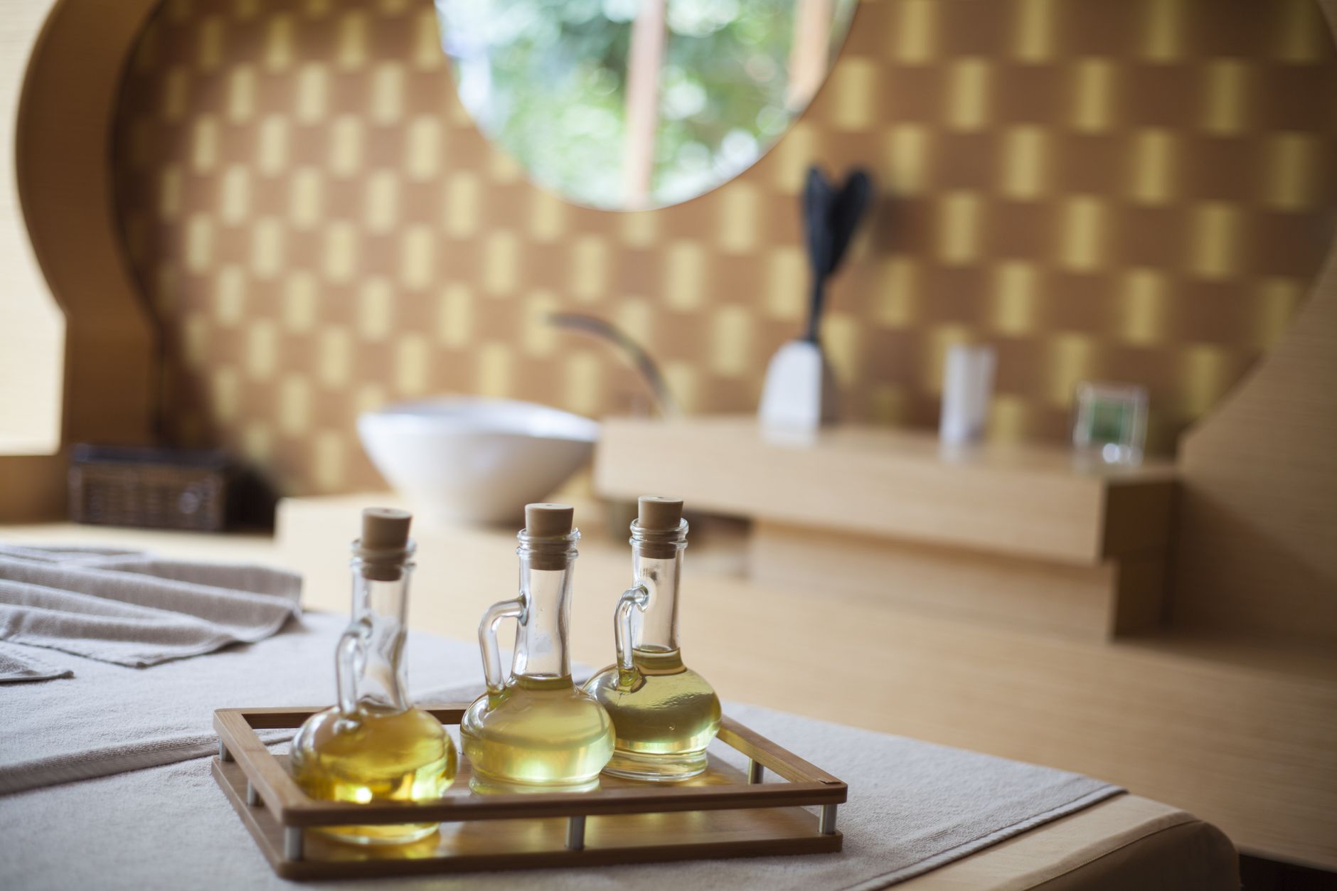 Spa treatment room with natural oil bottles on a wooden tray