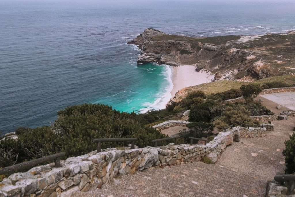 Cape Point rugged coastline with turquoise water and a boardwalk, supporting the reserve setting described in this section.