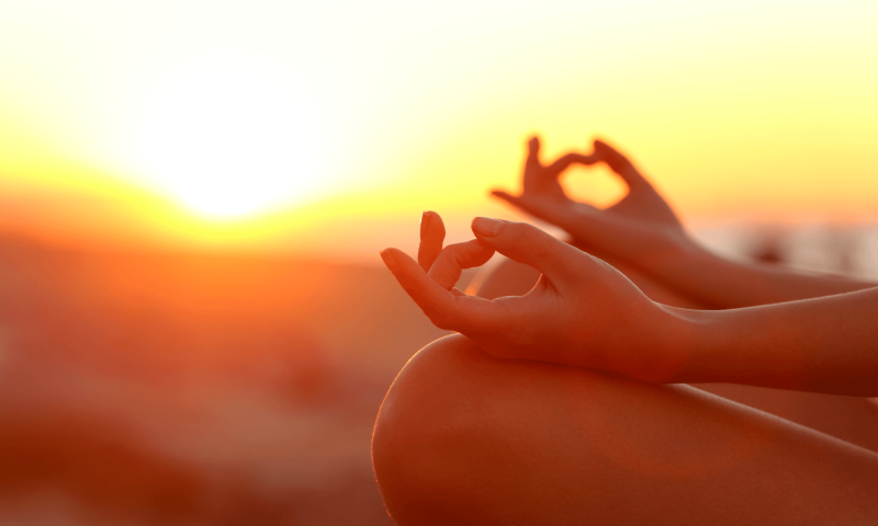 ands forming a heart at sunrise during a South African wellness journey