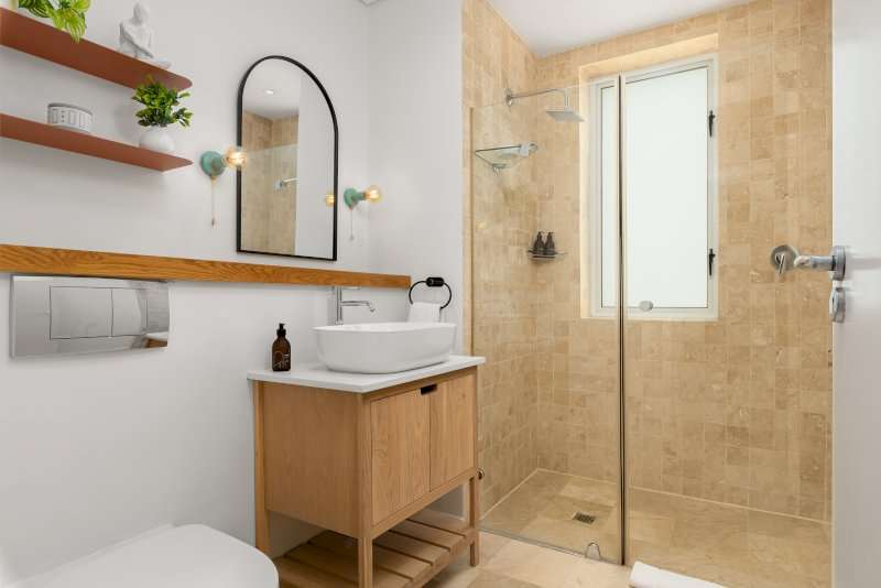 Carradale 3-Bed – Bathroom – Modern bathroom with a walk-in shower, natural stone finishes and contemporary vanity.
