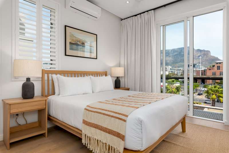 12. Carradale 3-Bed – Third Bedroom – Bright and elegant double bedroom with air-conditioning, warm natural finishes and beautiful views towards Table Mountain.
