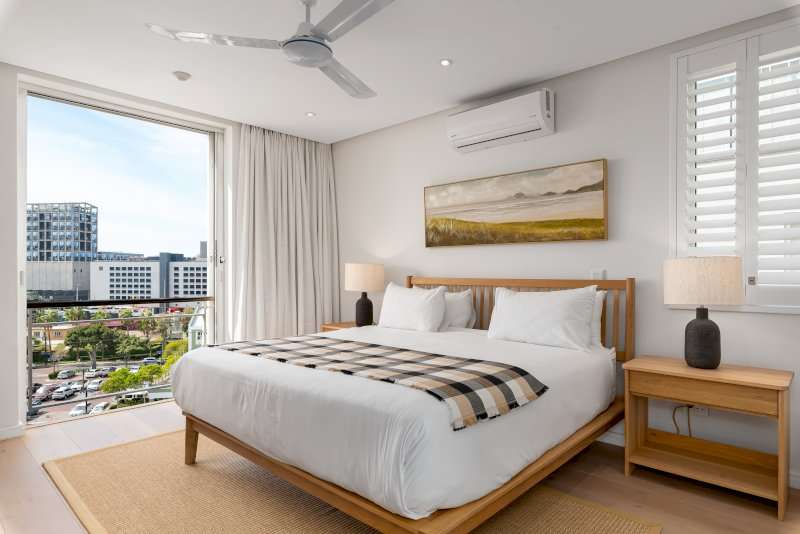 Carradale 3-Bed – Main Bedroom – Serene and spacious bedroom with a king-size bed, air-conditioning and large windows offering elevated city and Waterfront views.