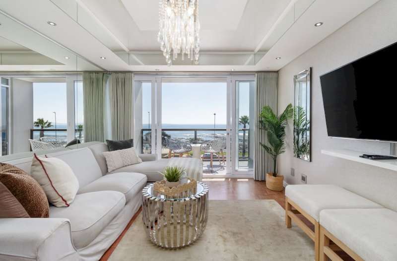 Mouille Point Seaside Stay – Lounge – Comfortable, stylish lounge with a large TV and direct access to the sea-facing balcony.