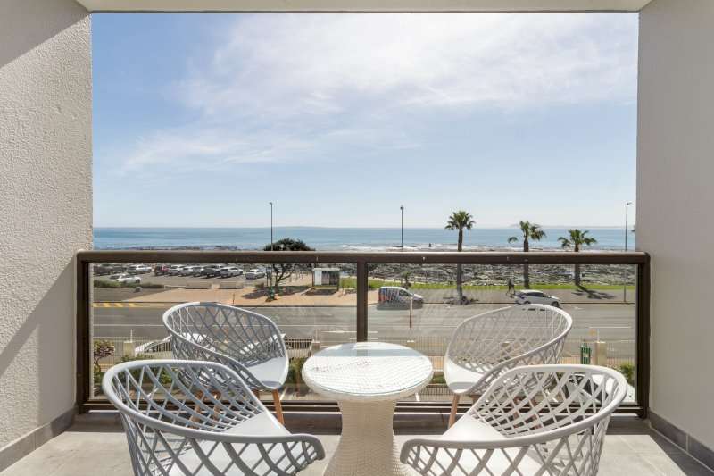 Mouille Point Seaside Stay – Balcony – Private balcony with outdoor seating and uninterrupted views across the Atlantic Ocean and Mouille Point promenade.