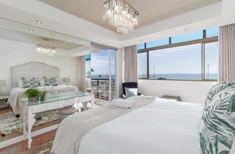 Mouille Point Seaside Stay – Main Bedroom Views – Bright, spacious bedroom with large windows showcasing sweeping views across the Atlantic Ocean.