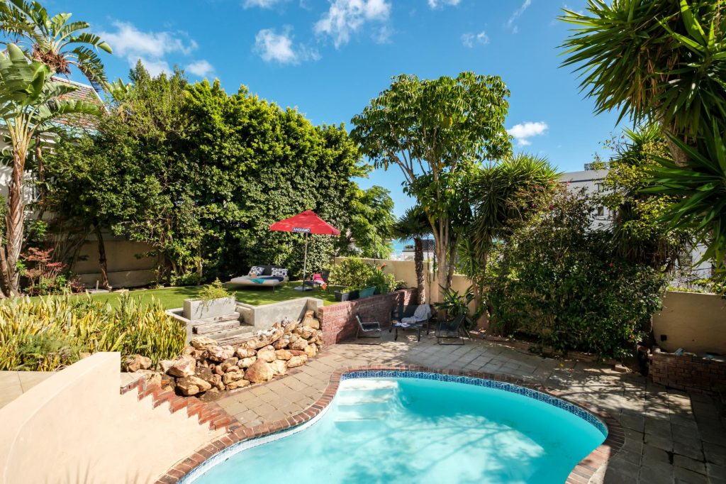 Kaya Eden – Private swimming pool surrounded by lush established greenery, with a peaceful garden relaxation area and shaded outdoor seating.