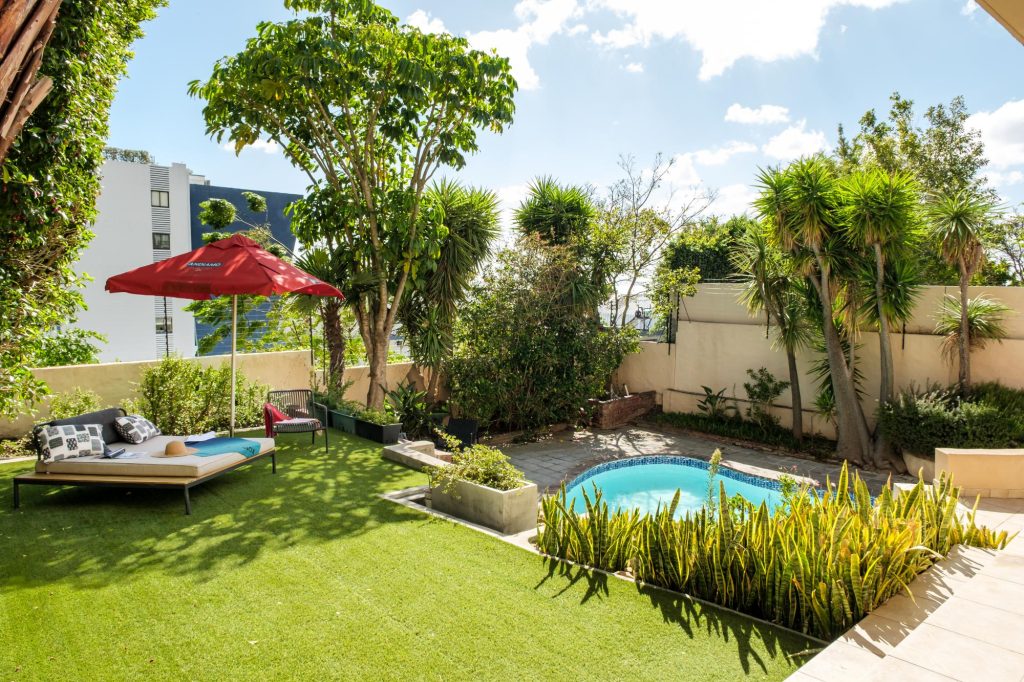 Kaya Eden – Tranquil garden and pool area with sun loungers, mature tropical planting and a secluded setting for leisurely afternoons outdoors.