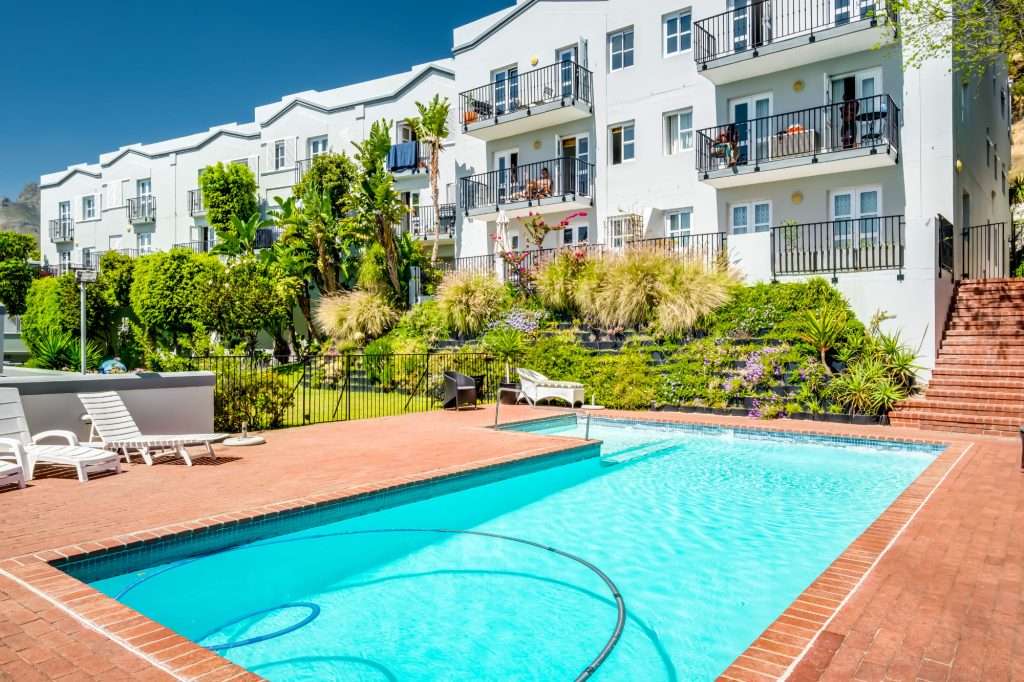 De Waterkant DW-001 – Communal Swimming Pool – Inviting swimming pool surrounded by sun loungers and beautifully maintained landscaped gardens.
