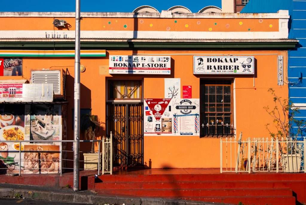 Bo-Kaap street scene with a colourful barber shop facade in Cape Town.