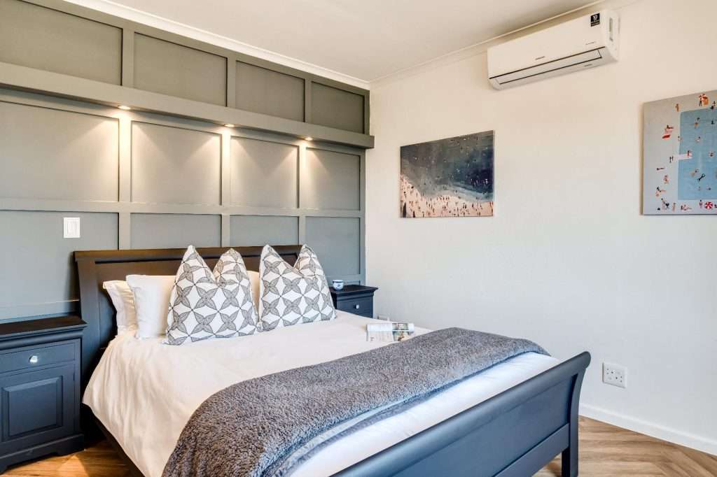 Shoreline Views – First Bedroom – Comfortable double bedroom with air-conditioning, stylish feature panelling and soft contemporary furnishings.