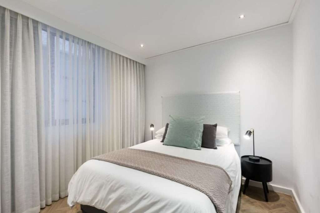 The Tuynhuys – Second Bedroom – Comfortable second bedroom with crisp linen, soft contemporary furnishings and bedside reading lights.