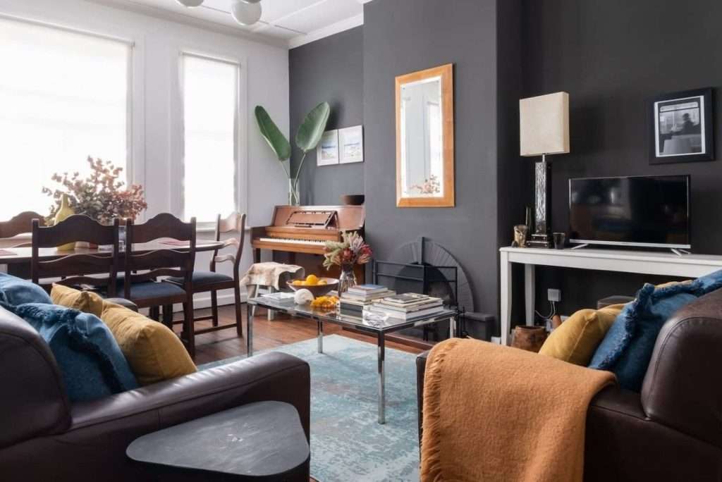 Timeless Sea Point Retreat – Living & Dining Room – Characterful open living space with comfortable leather seating, dining area, television and distinctive dark feature wall.