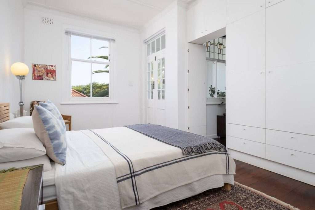 Timeless Sea Point Retreat – Main Bedroom – Spacious, airy bedroom with generous built-in storage, wooden floors and beautiful period proportions.