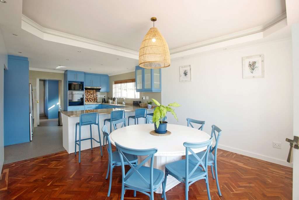 The Perch – Kitchen & Dining – Spacious open-plan dining area flowing into the kitchen, with breakfast-bar seating and a relaxed coastal feel.