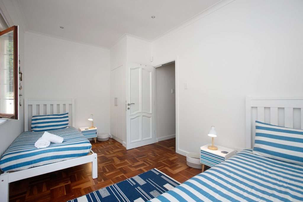The Perch – Twin Bedroom – Fresh, comfortable twin bedroom with coastal blue-and-white décor, ideal for children or additional guests.