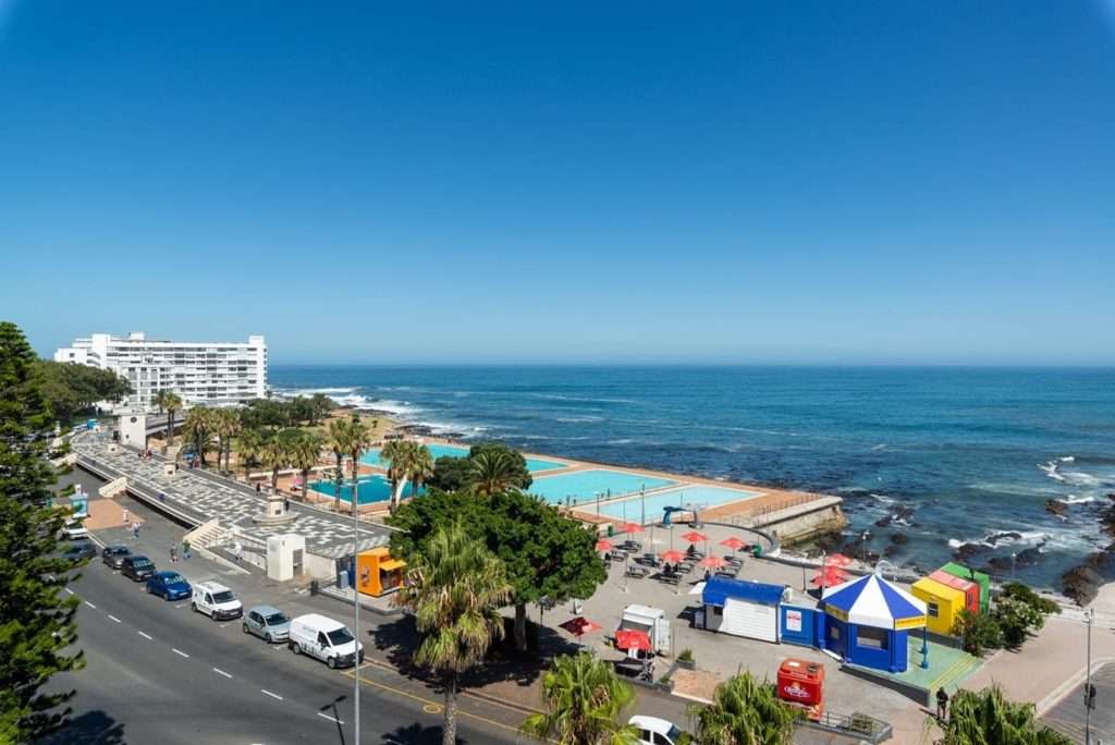 Mimosa Views – Breathtaking elevated views over the Sea Point Pavilion swimming pools, palm-lined promenade and sparkling Atlantic Ocean, capturing the vibrant beauty of Cape Town's Atlantic Seaboard.
