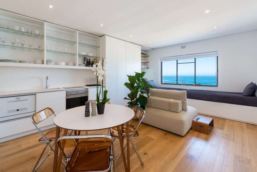 Mimosa Views – Inviting living and dining space with comfortable seating, a fully equipped kitchen and a large picture window framing spectacular Atlantic Ocean views.