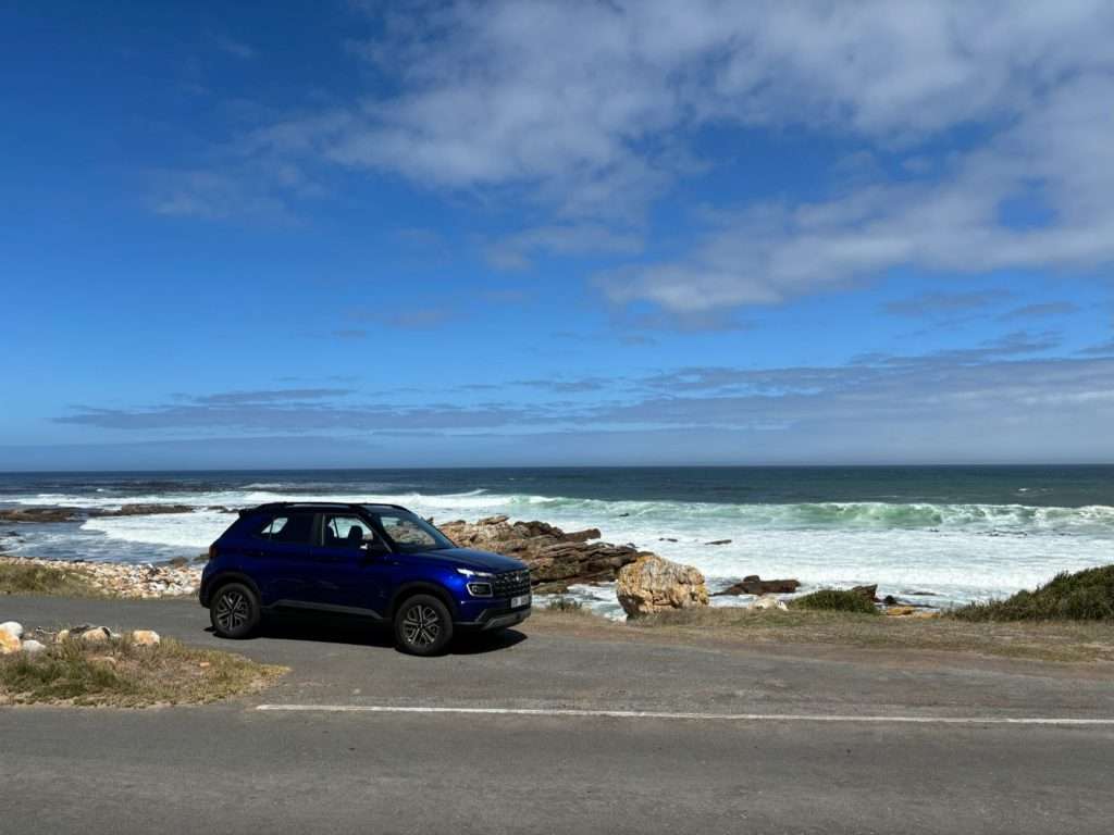 Blue SUV parked by the coast in Cape Town.