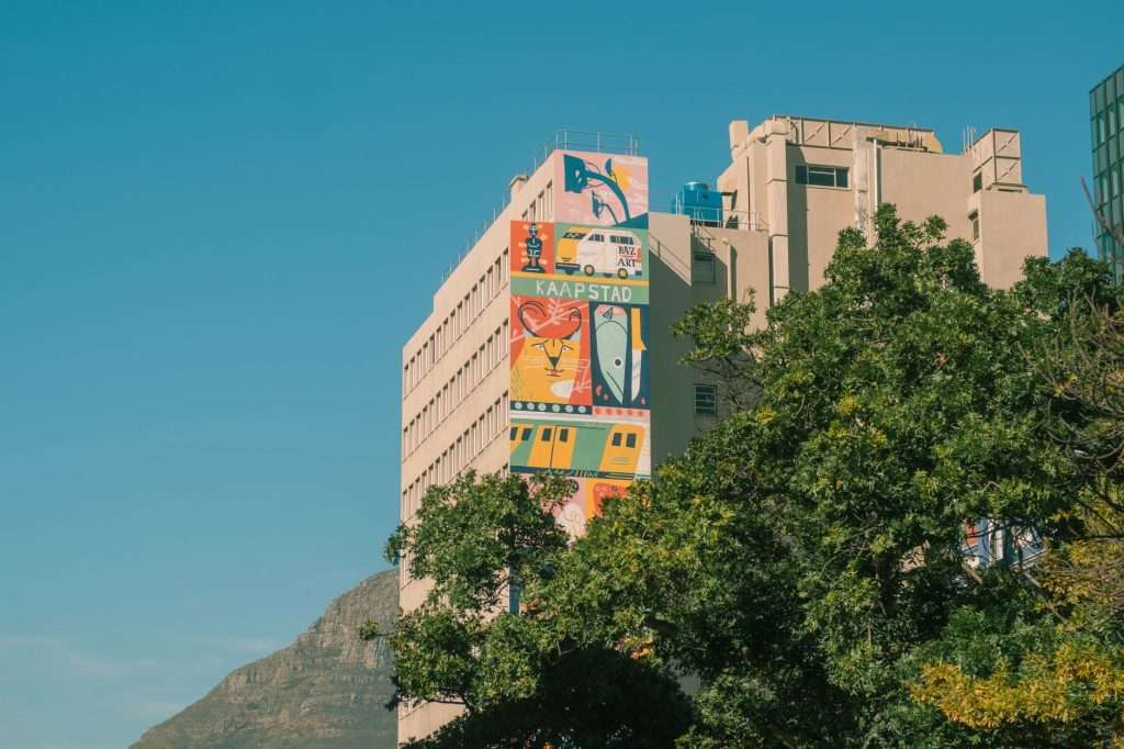Colorful mural on a building in Cape Town against a clear blue sky.