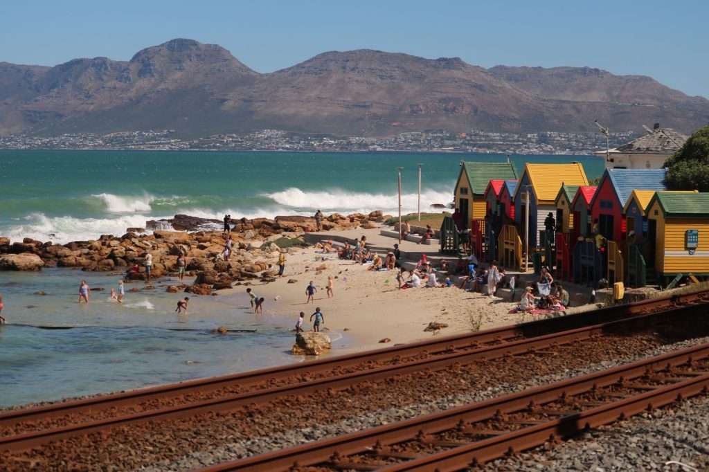 St James Beach with colourful huts and a calm False Bay shoreline in Cape Town.