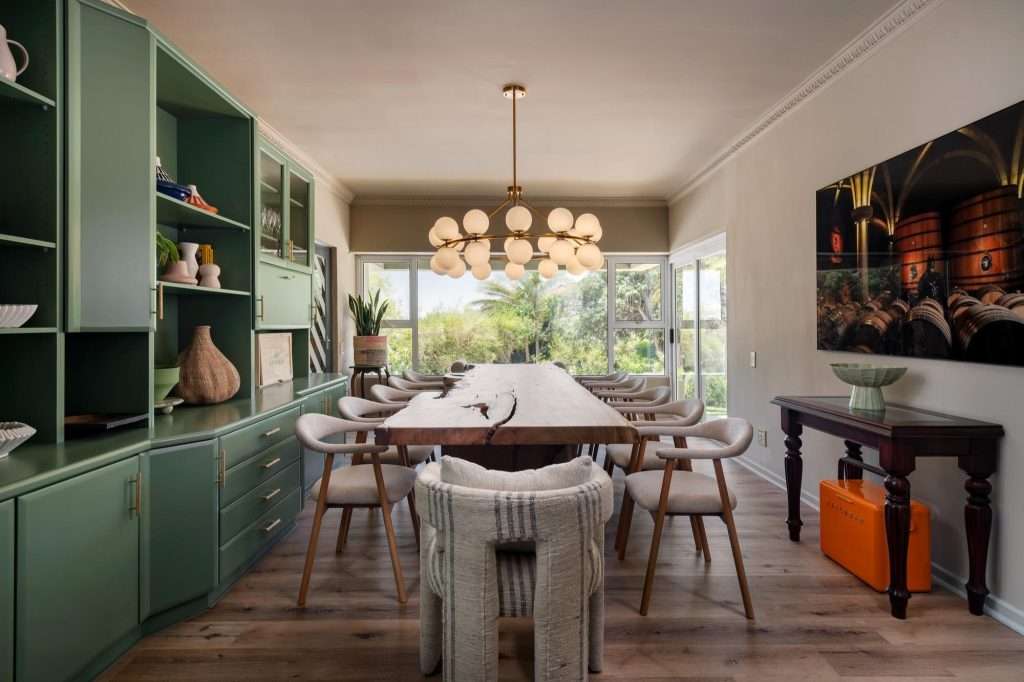 Kinvara Villa – Dining Room – Sophisticated dining space centred around a generous timber table, with bespoke green cabinetry and contemporary statement lighting.