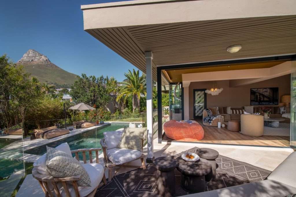 Kinvara Villa – Indoor-Outdoor Living – Covered outdoor lounge flowing directly from the main living area to the pool and garden, with Lion’s Head providing a spectacular backdrop.